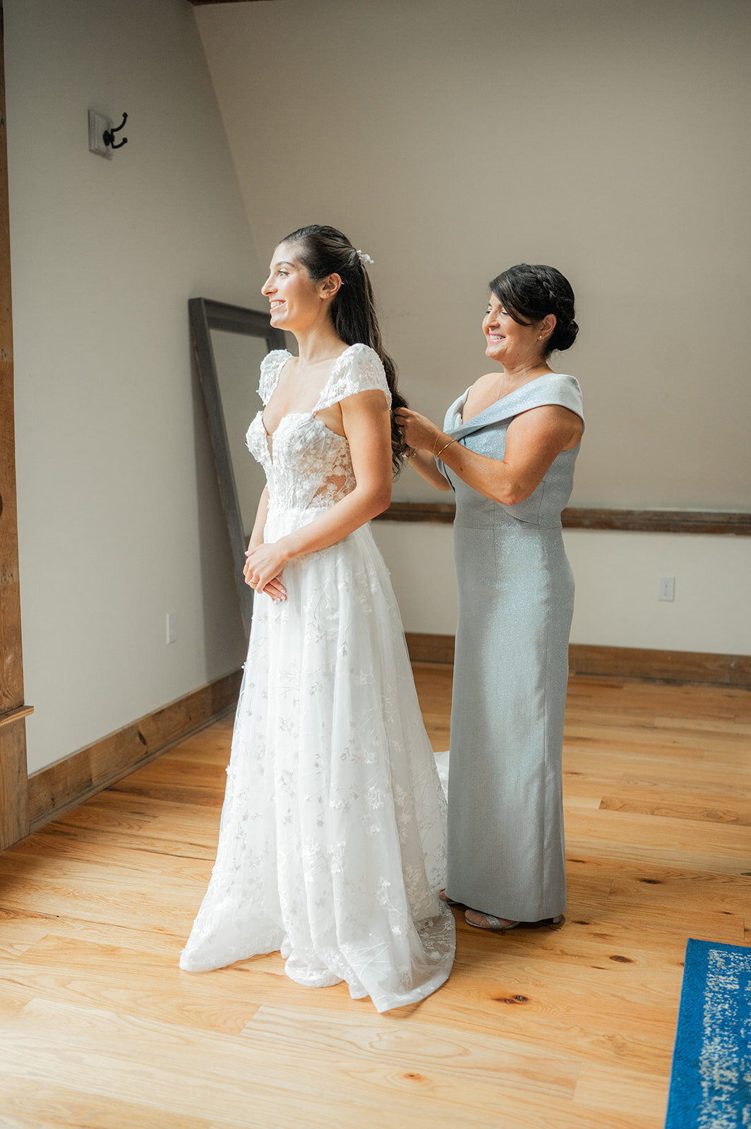 bride outting on her drfess with mother for sity winery wedding