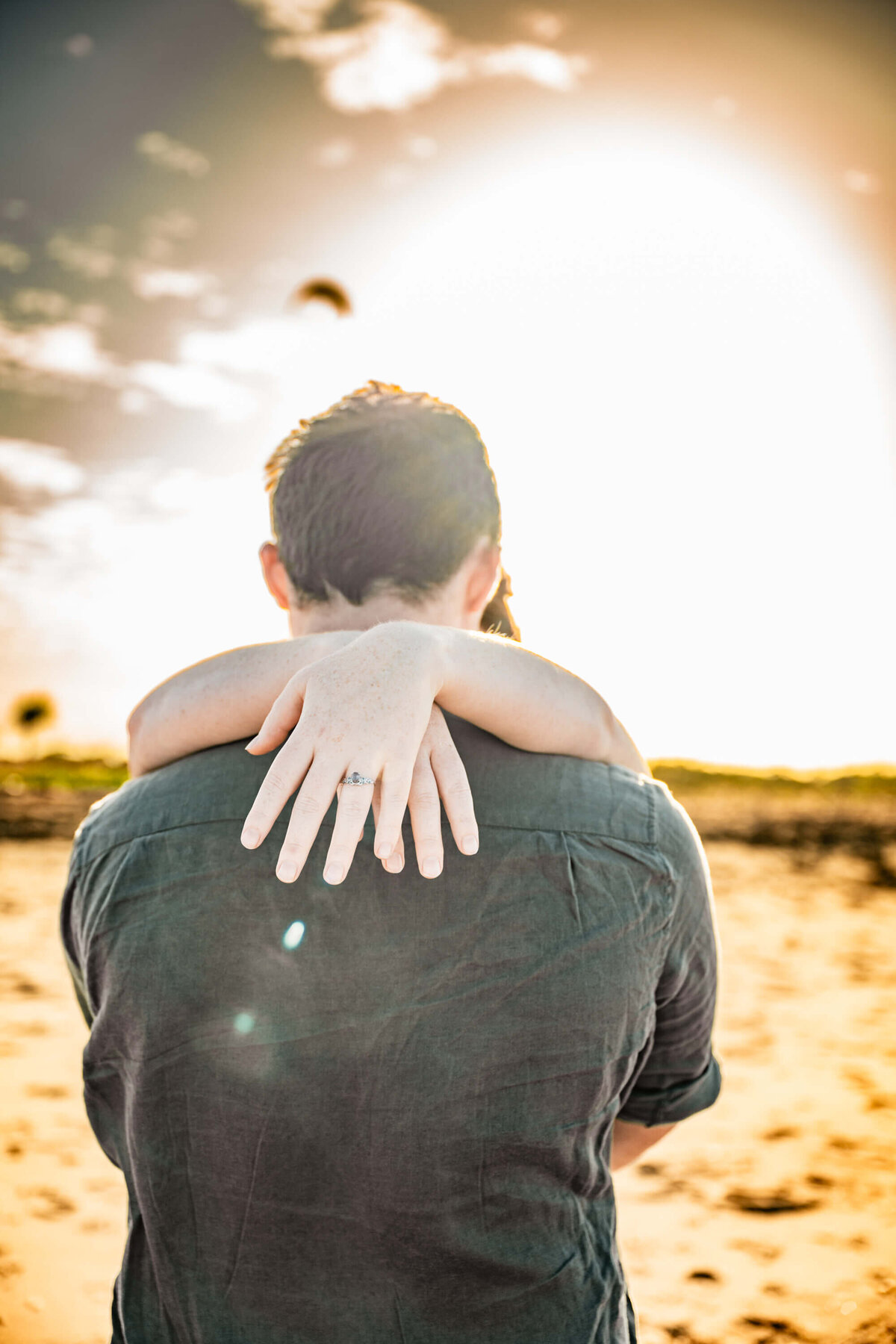 A man and woman embrace on the beach, silhouetted against a vibrant sunset sky.  - photo by Jamie Simmons