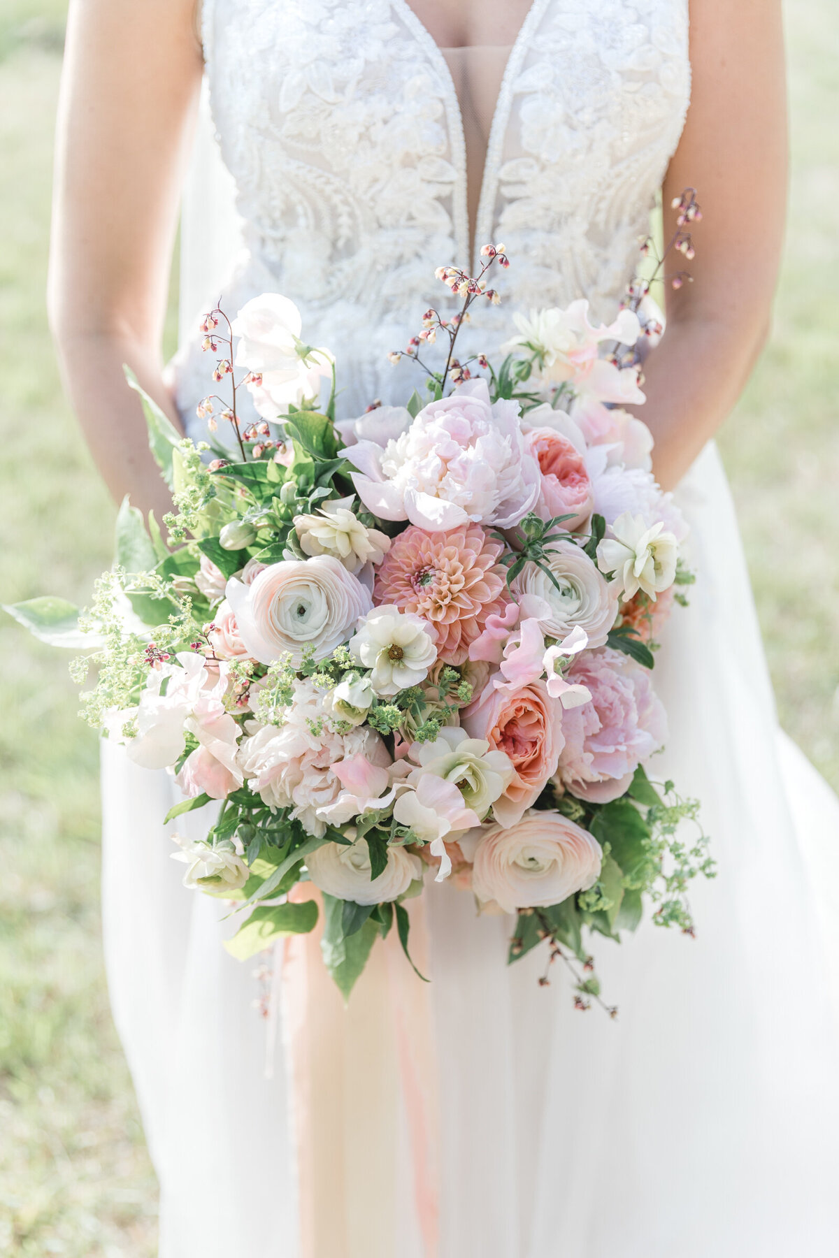 A close up of a romantic garden style bridal bouquet with soft pink hues