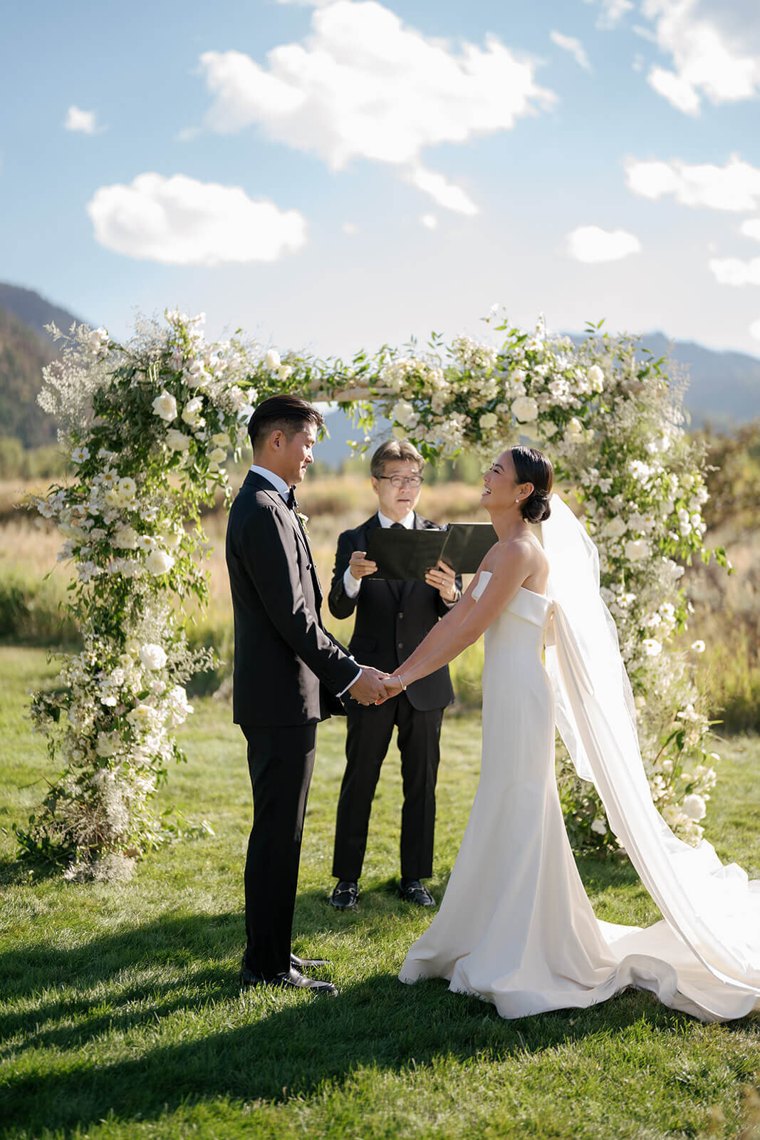 Bride and groom standing together during their wedding ceremony at Aspen Meadows Resort, sharing a tender moment surrounded by nature.
