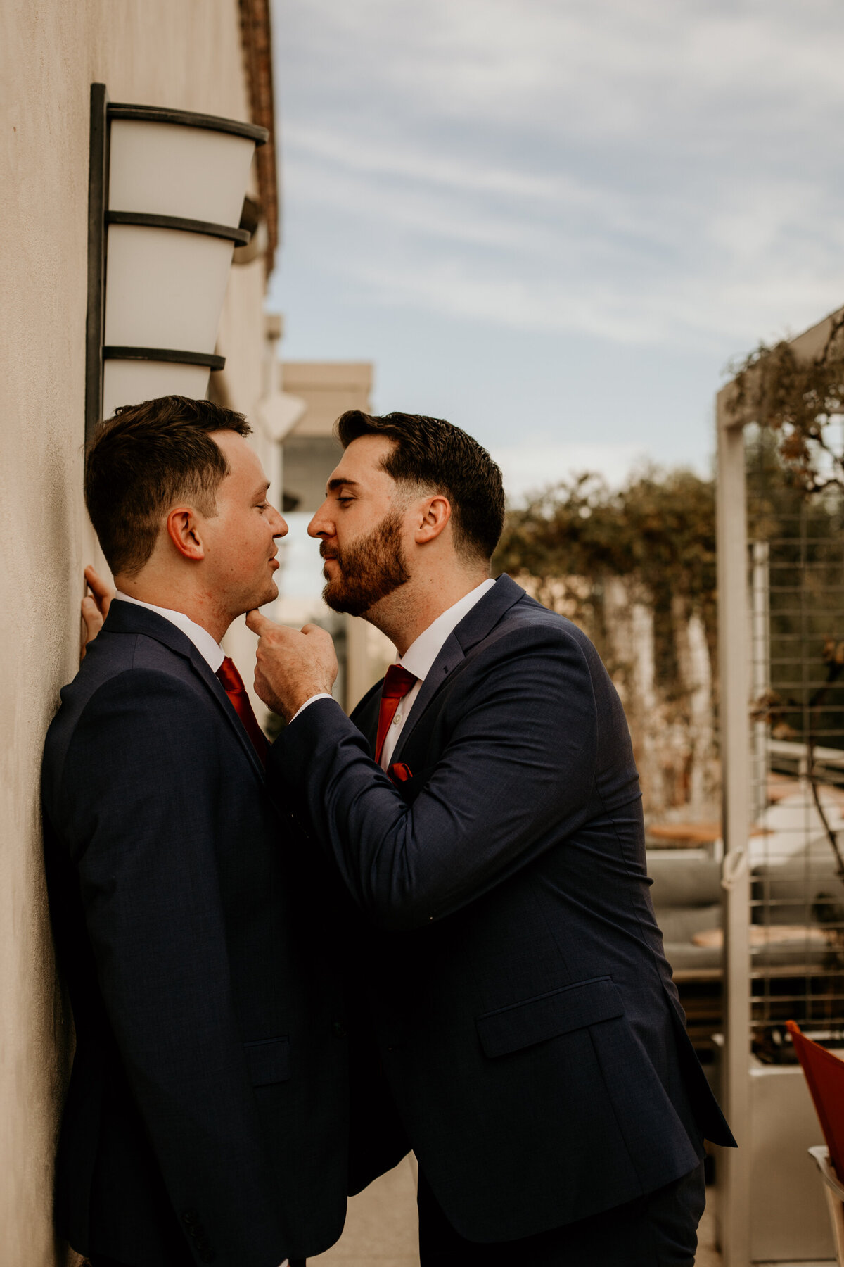 two grooms about to kiss on a balcony in downtown Albuquerque