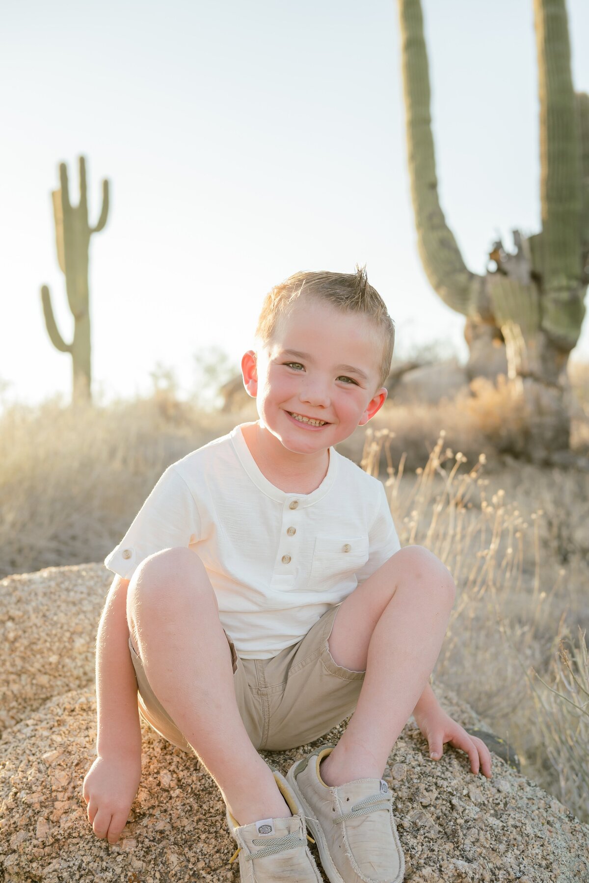 little boys sitting on a rock in the arizona desert
