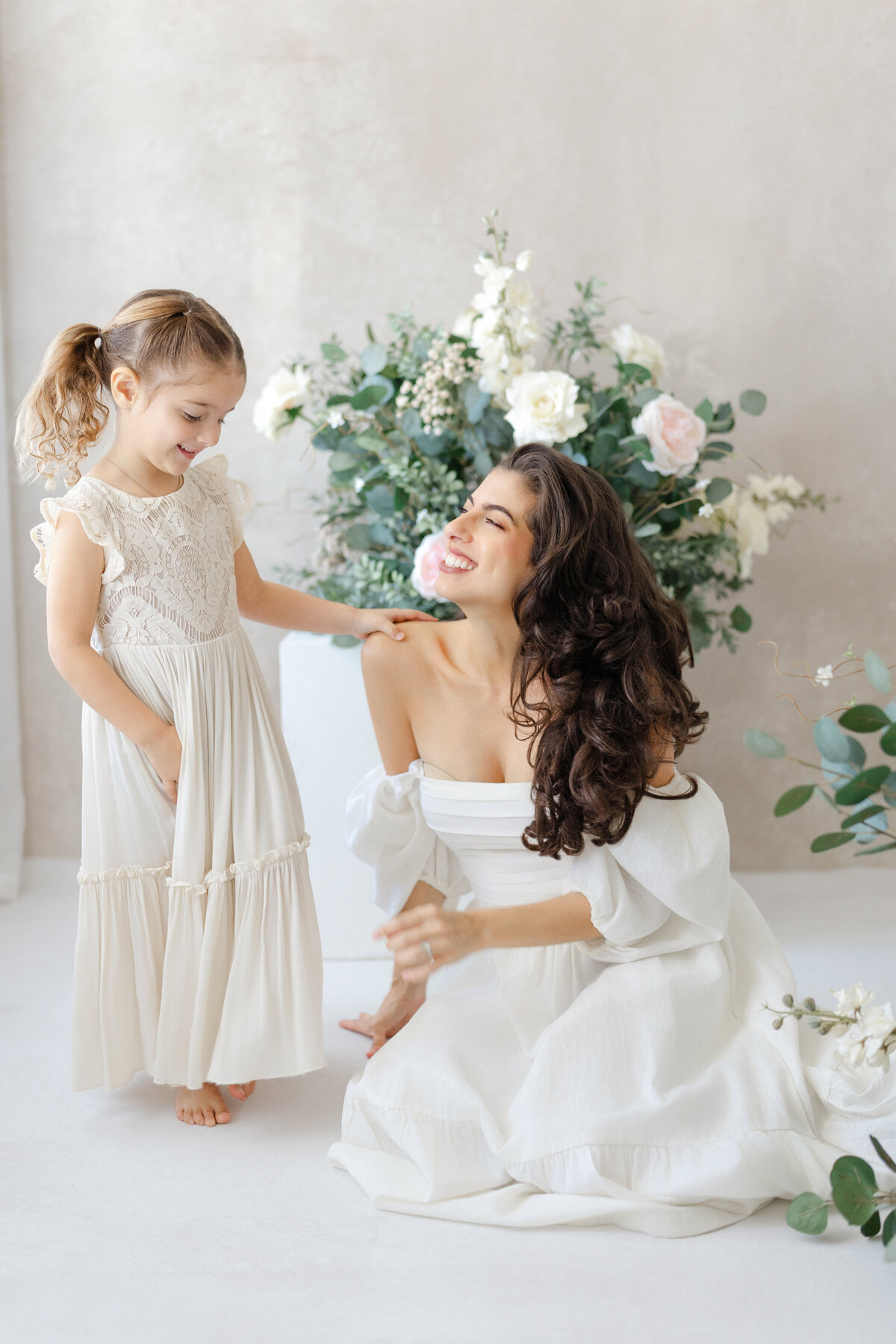 Joyful Tampa motherhood portrait of mom and daughter laughing together in soft natural light studio