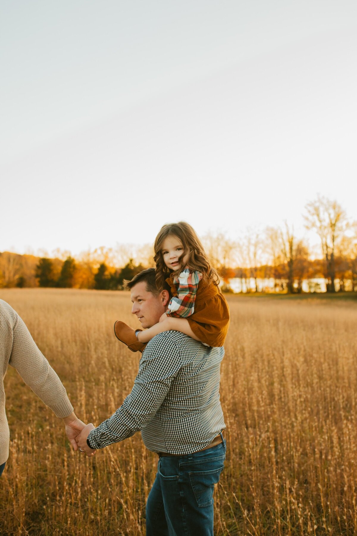 a little girl riding on her dad's shoulders