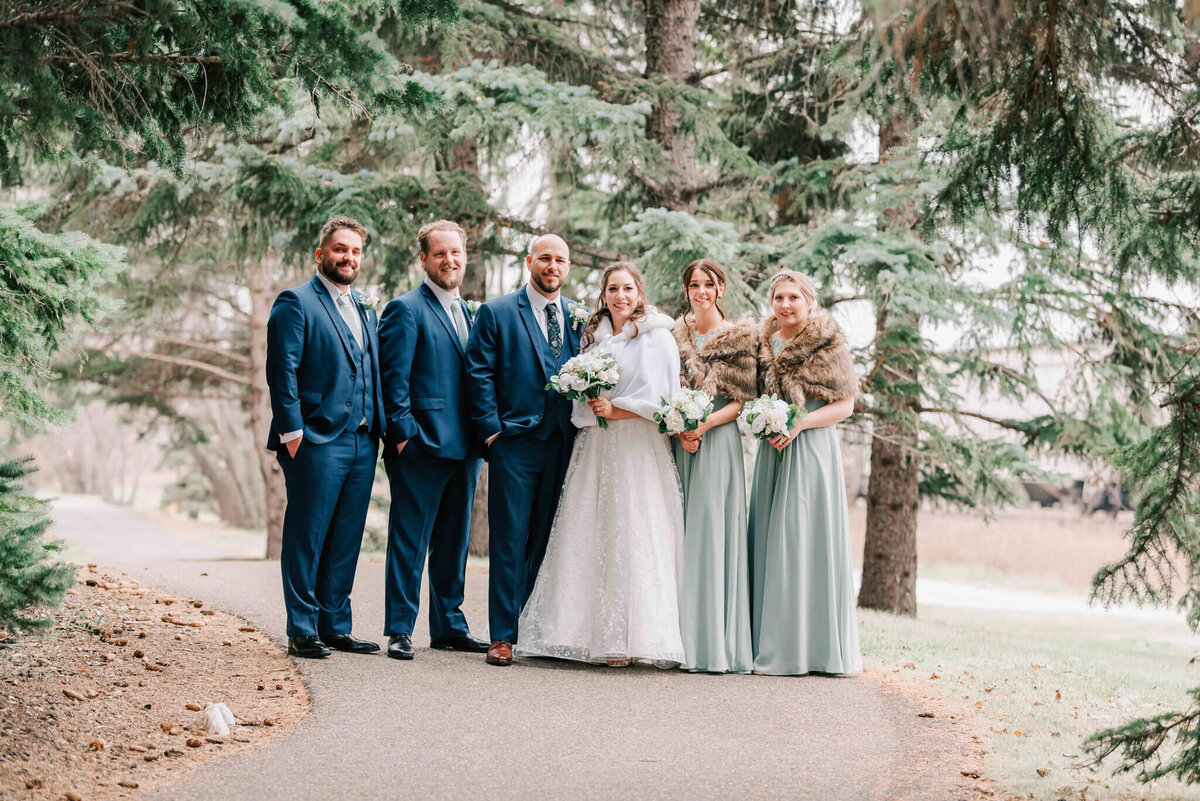 Bride and groom stand outside with the bridal party. 