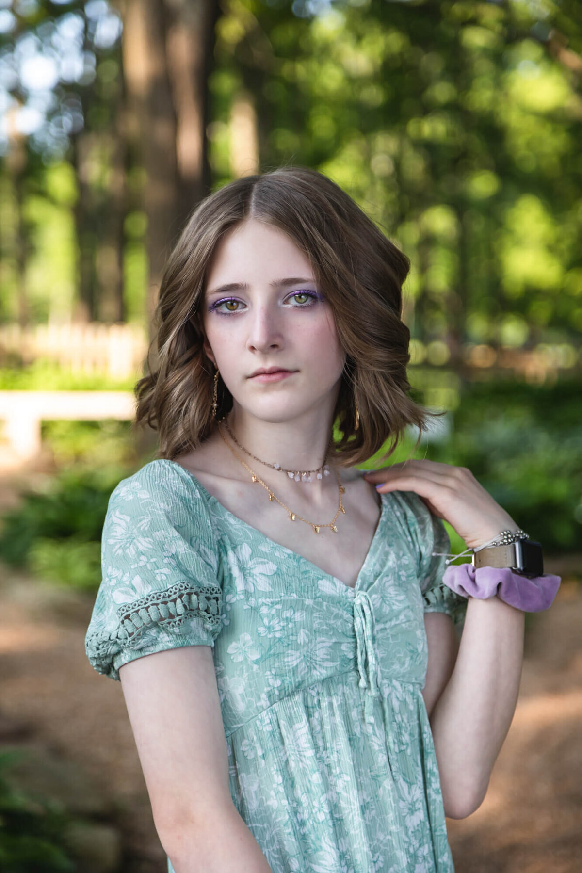 Portrait of beautiful teen girl with piercing green eyes wearing a light green dress. Captured by Springfield, MO teen photographer Dynae Levingston