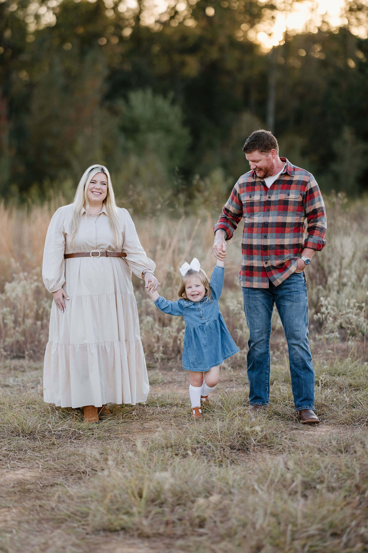 East Texas family posing in open Longview, Texas field for family photos