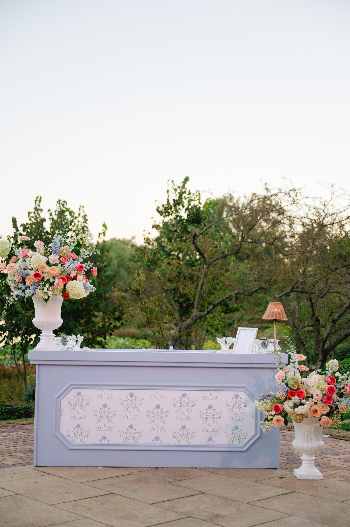Outdoor wedding bar setup with floral arrangements