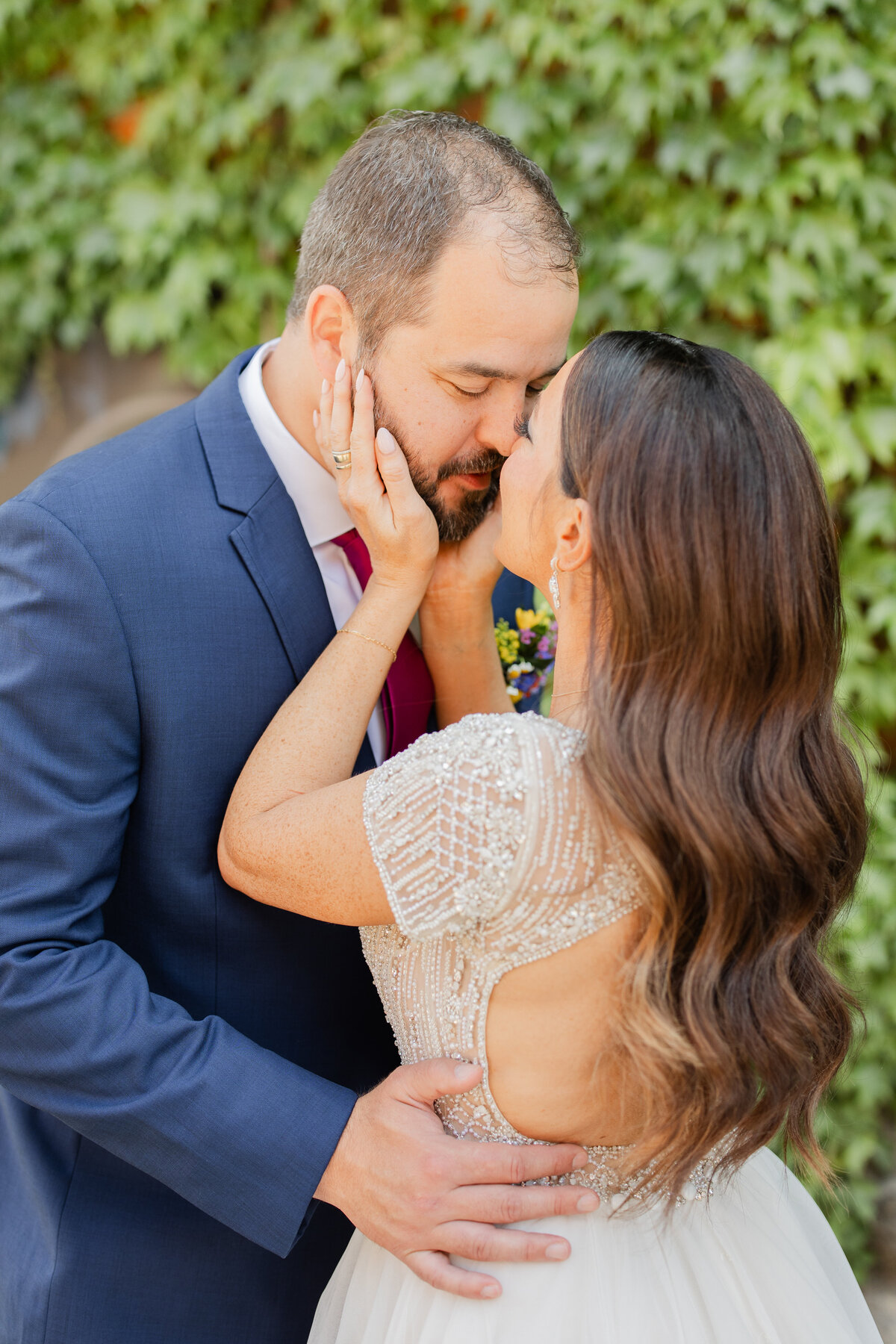 Bride and groom sharing a kiss on their wedding day. Bridal beauty services in Rockford, IL.