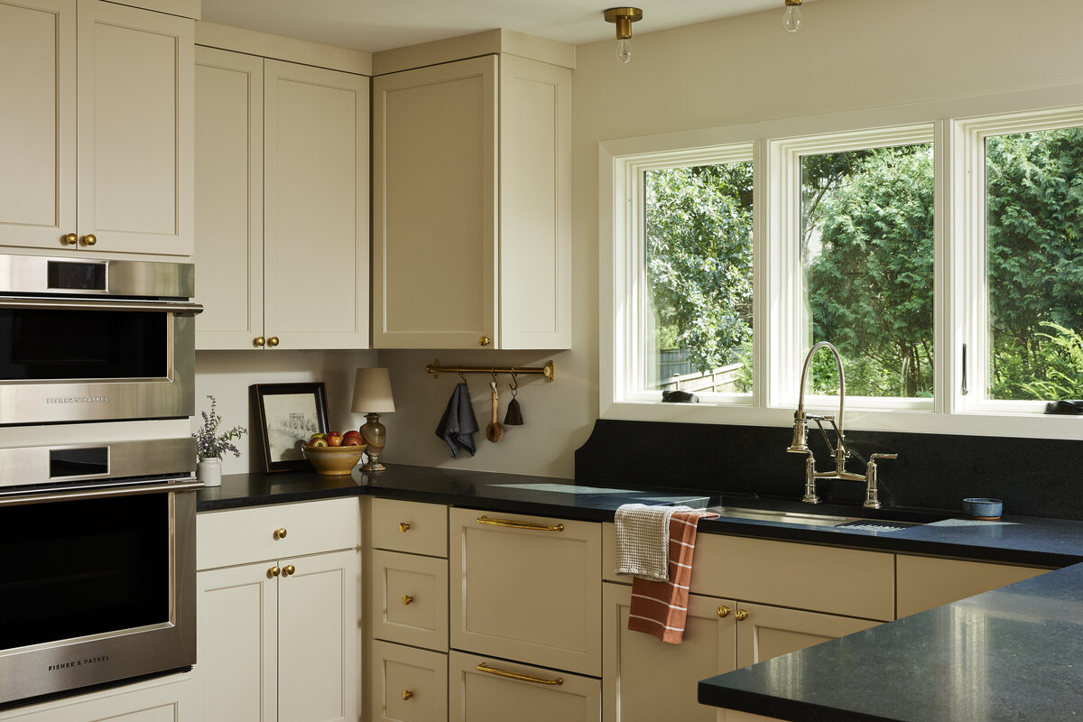 Honed black granite countertops with scalloped backsplash behind sink, polished nickel bridge faucet, MN remodel, Minnesota kitchen renovation