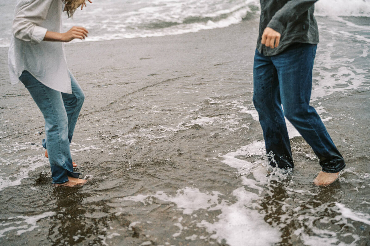 Face less couple splashing in the waves. 