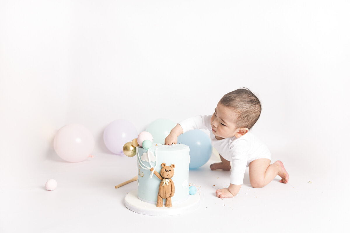 Curious toddler during cake smash photoshoot in-home on the pop-up studio.