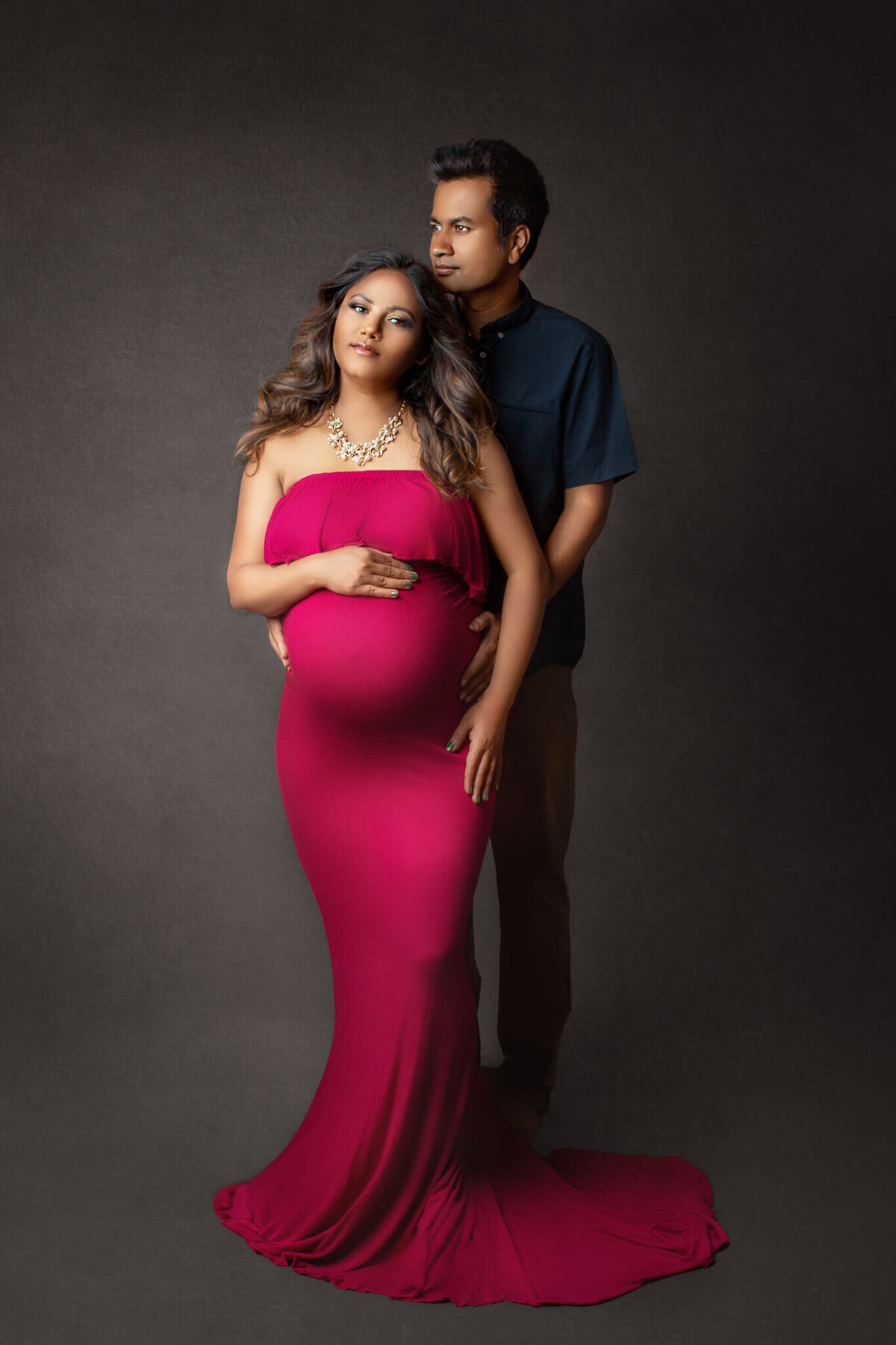 couple poses for maternity portraits in Hamilton, ON photography studio