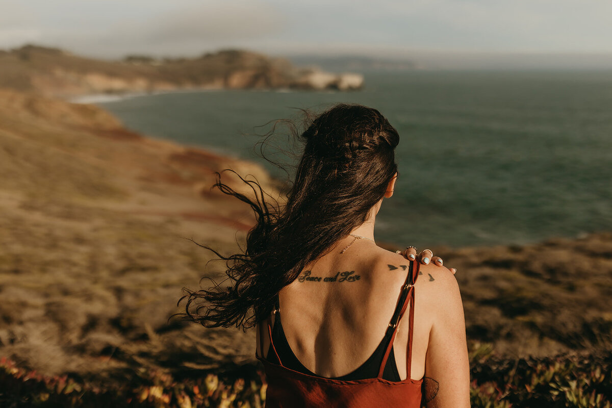 Content storytelling for brand of woman's back with tattoo looking toward the San Francisco Bay