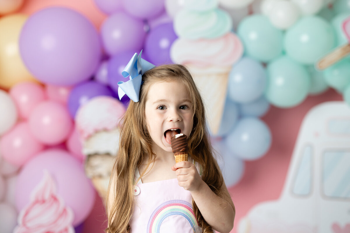 Sweet girl enjoying her ice cream birthday setup, capturing fun and messy moments in a themed session by Victoria Lee Photography in Canton, GA.