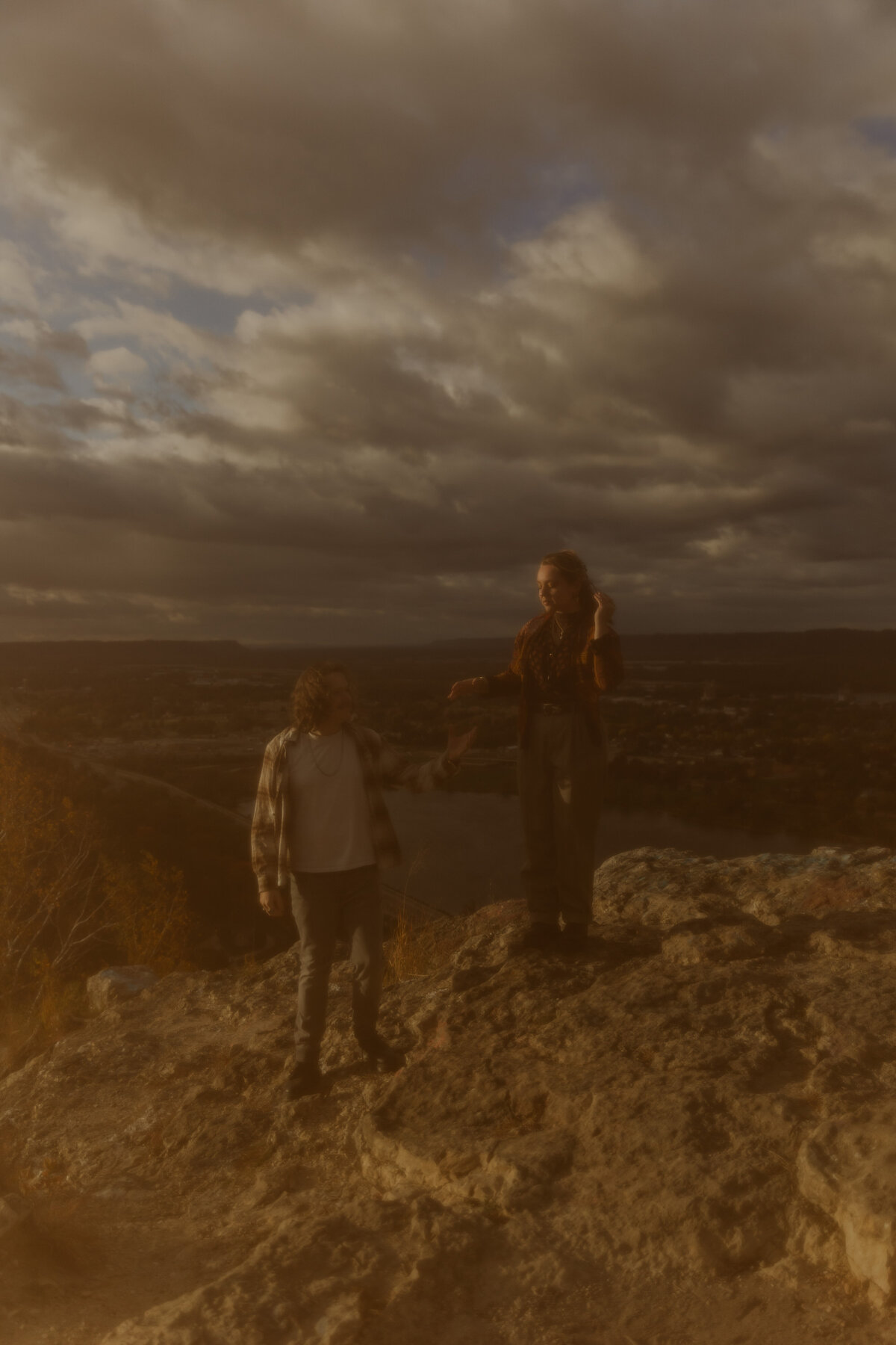 Moody Photo of a Couple Standing on the Edge of a Cliff during their Photoshoot in Colorado 