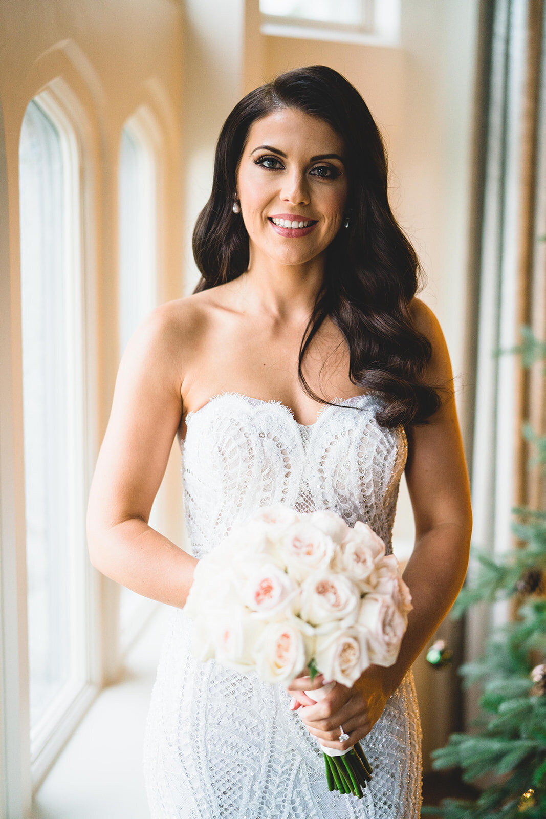 The bride looking towards camera with 1920s her in a Berta wedding dress holding her flowers