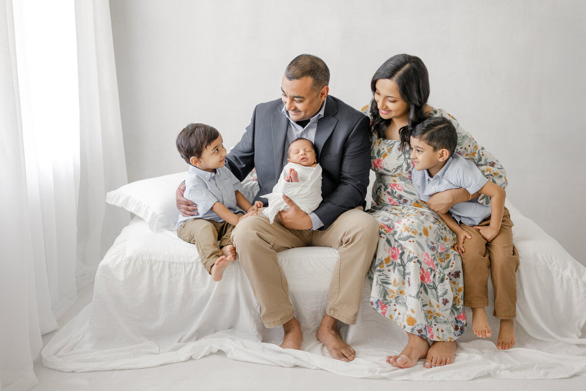 Newborn baby in soft neutral wrap during luxury natural light studio session in Tampa with timeless styling