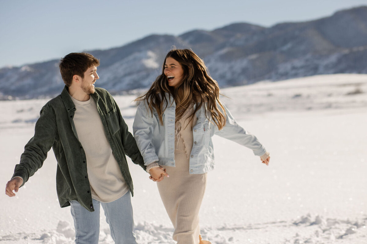 Cute couple running in snowy mountains