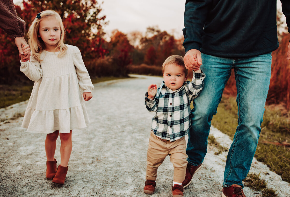 Sister and brother holding mom's and dad's hand