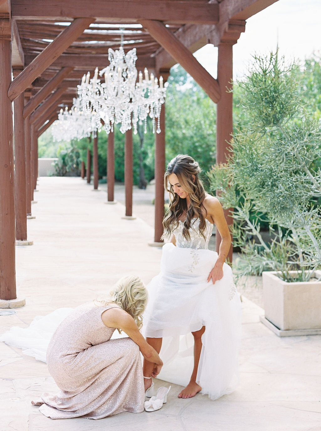 A heartfelt wedding preparation moment as the bride's mother helps with final touches. This intimate and emotional wedding detail highlights the special bond between mother and daughter.