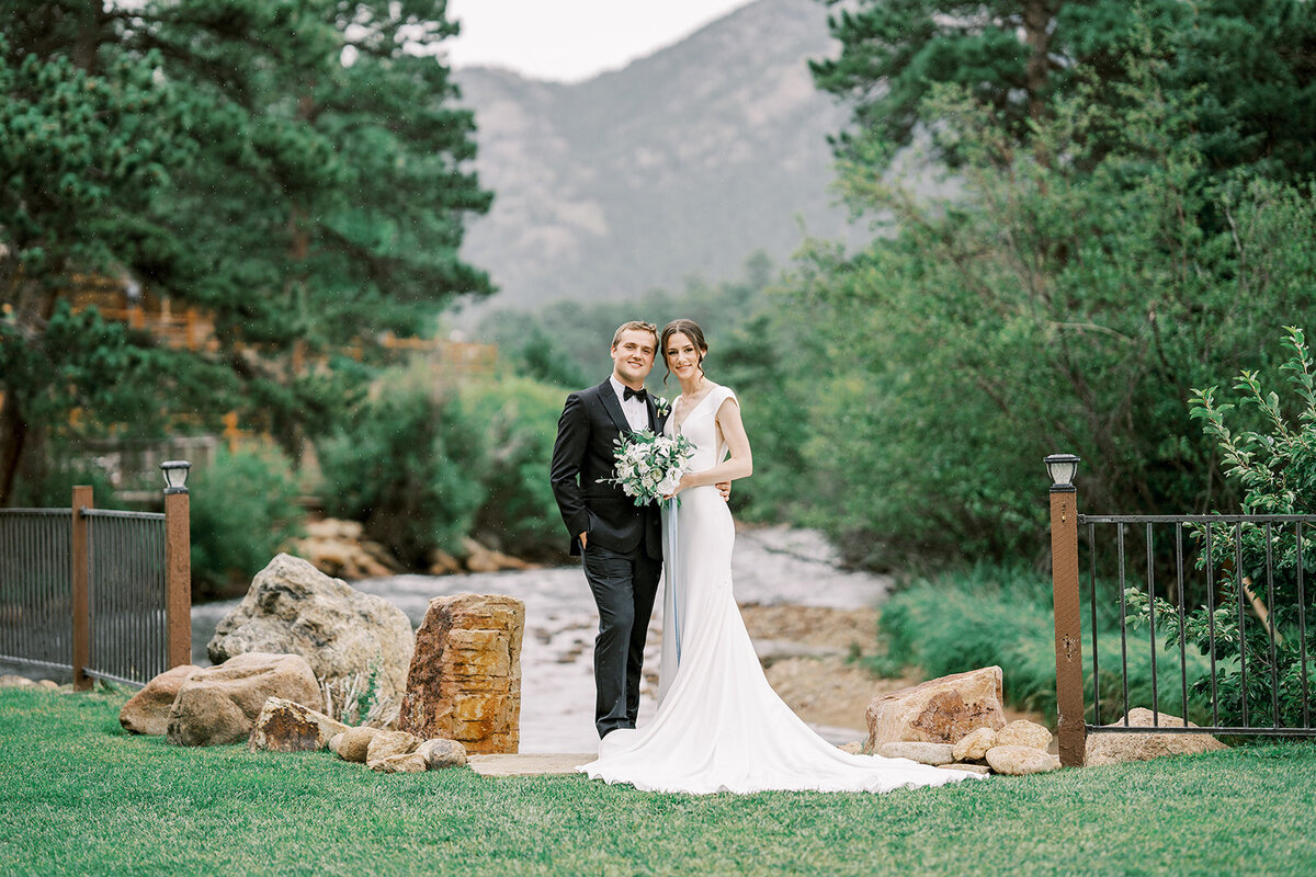 Bride and groom pose in their wedding ceremony location at the Landing in Estes Park.