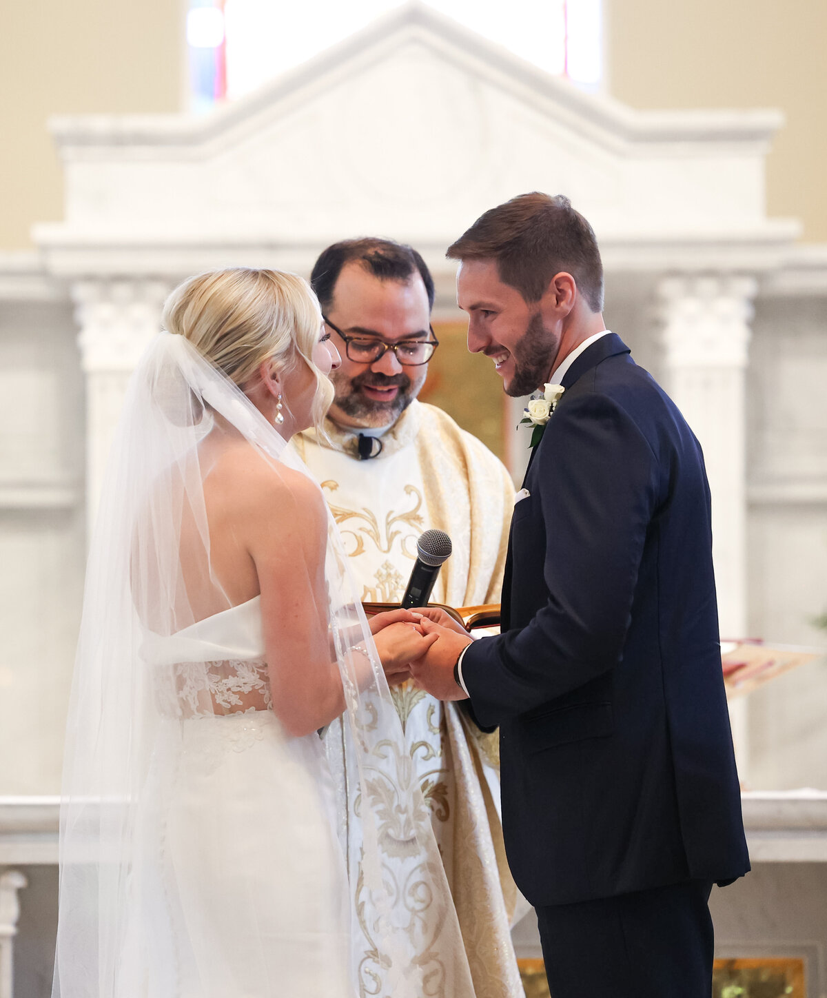 bride and groom exchanging rings in Catholic church in Atlanta Georgia by Atlanta wedding. photographer Amanda Richardson Photography