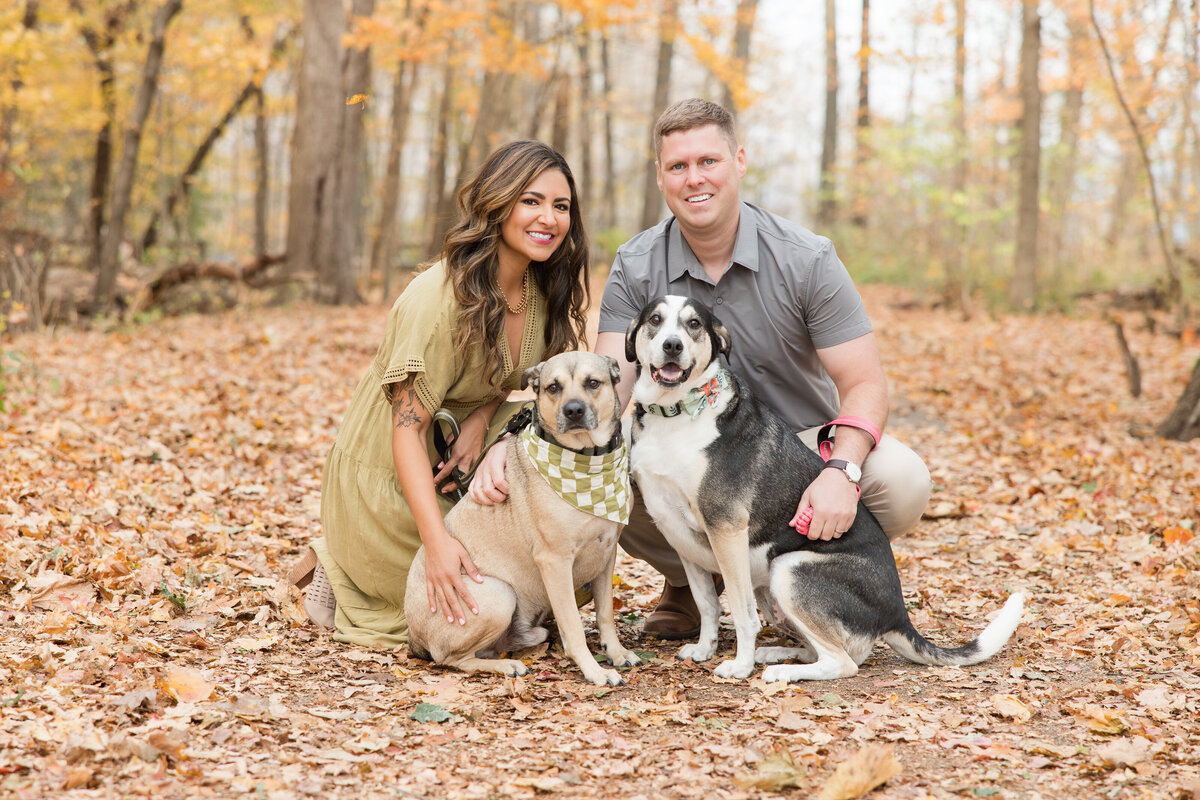Married couple smiling at the camera with their dogs
