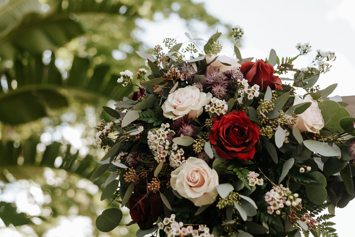 alt="florals on wedding arch"