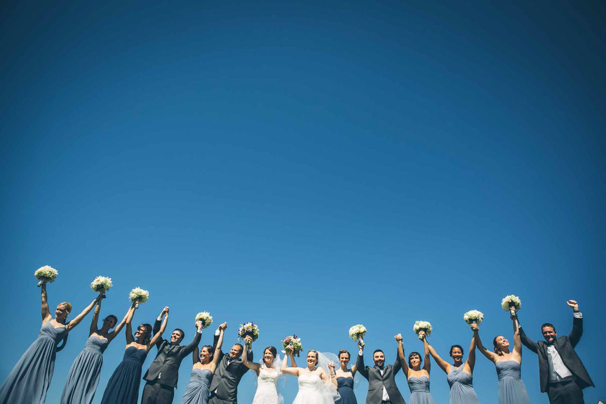 bridal party cheering under a blue ski