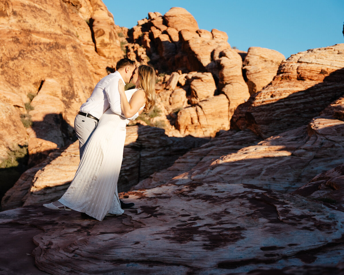 man kisses his fiance in the nevada desert at sunset