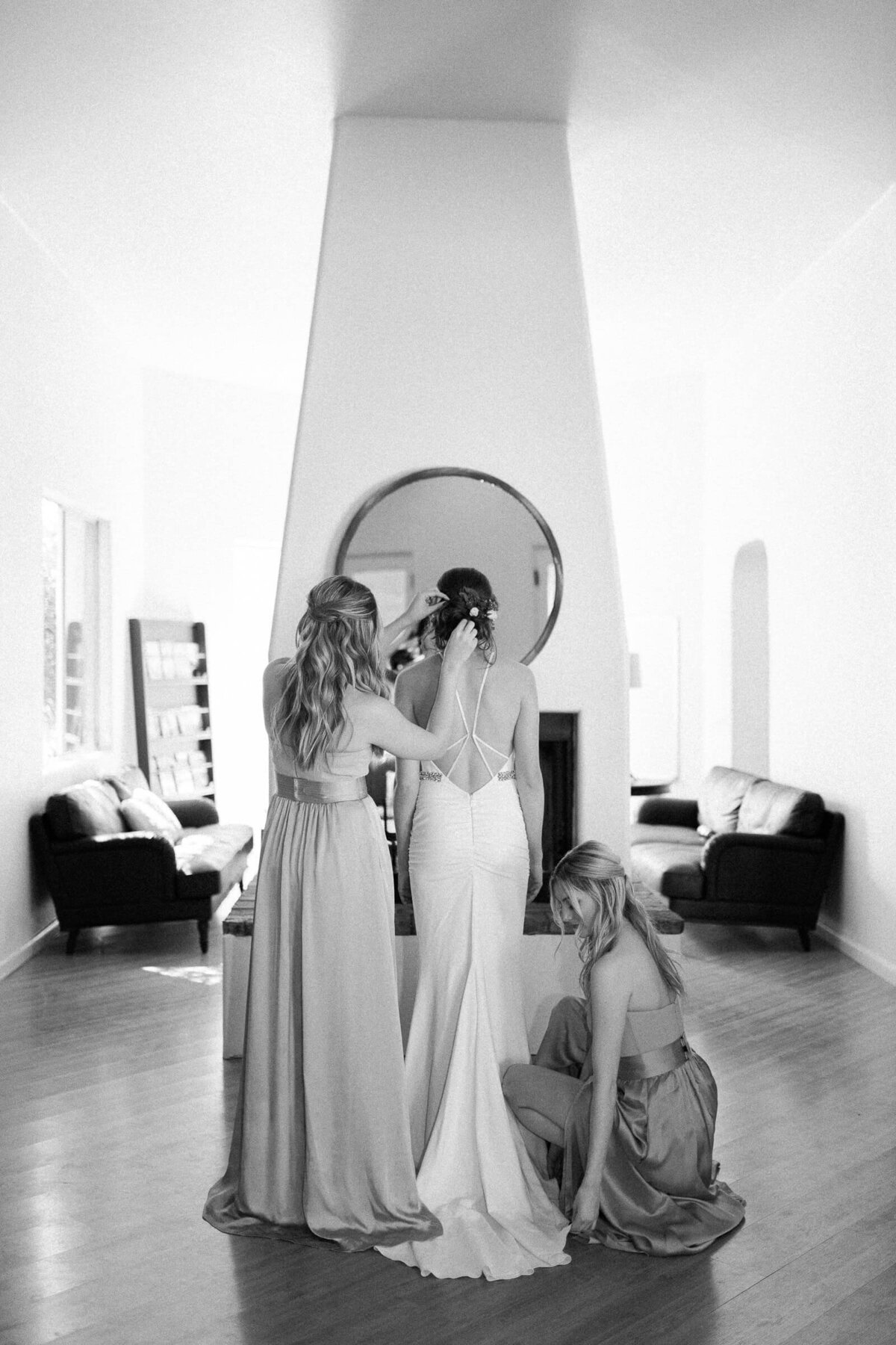 ridesmaids helping the bride with final touches in a bright, modern space, photographed by an East Coast wedding photographer capturing candid, emotional moments.