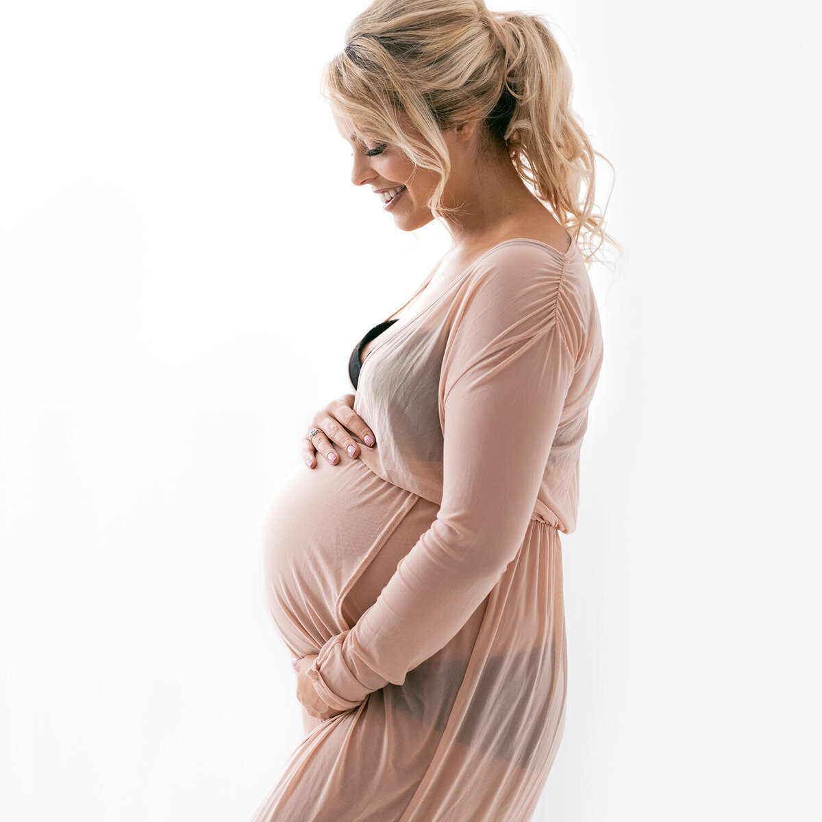 Artistic maternity photography of a woman showing off her bump
