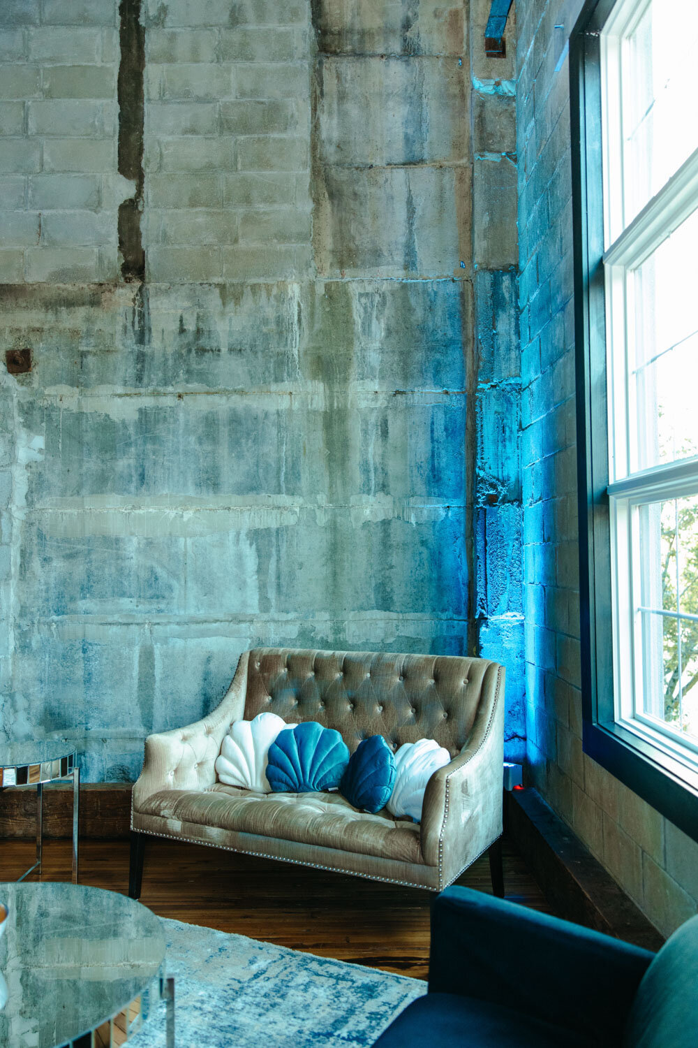Stylish seating area with a tufted couch against a textured wall