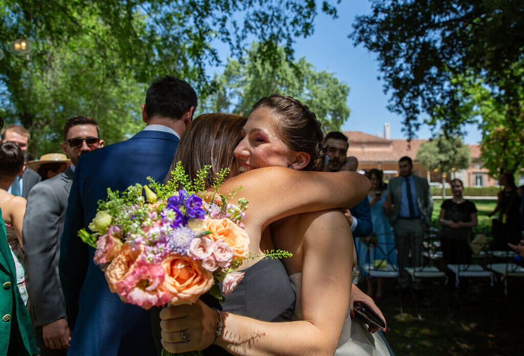 Just married bride hugs guest in sunshine at Casa De Monico