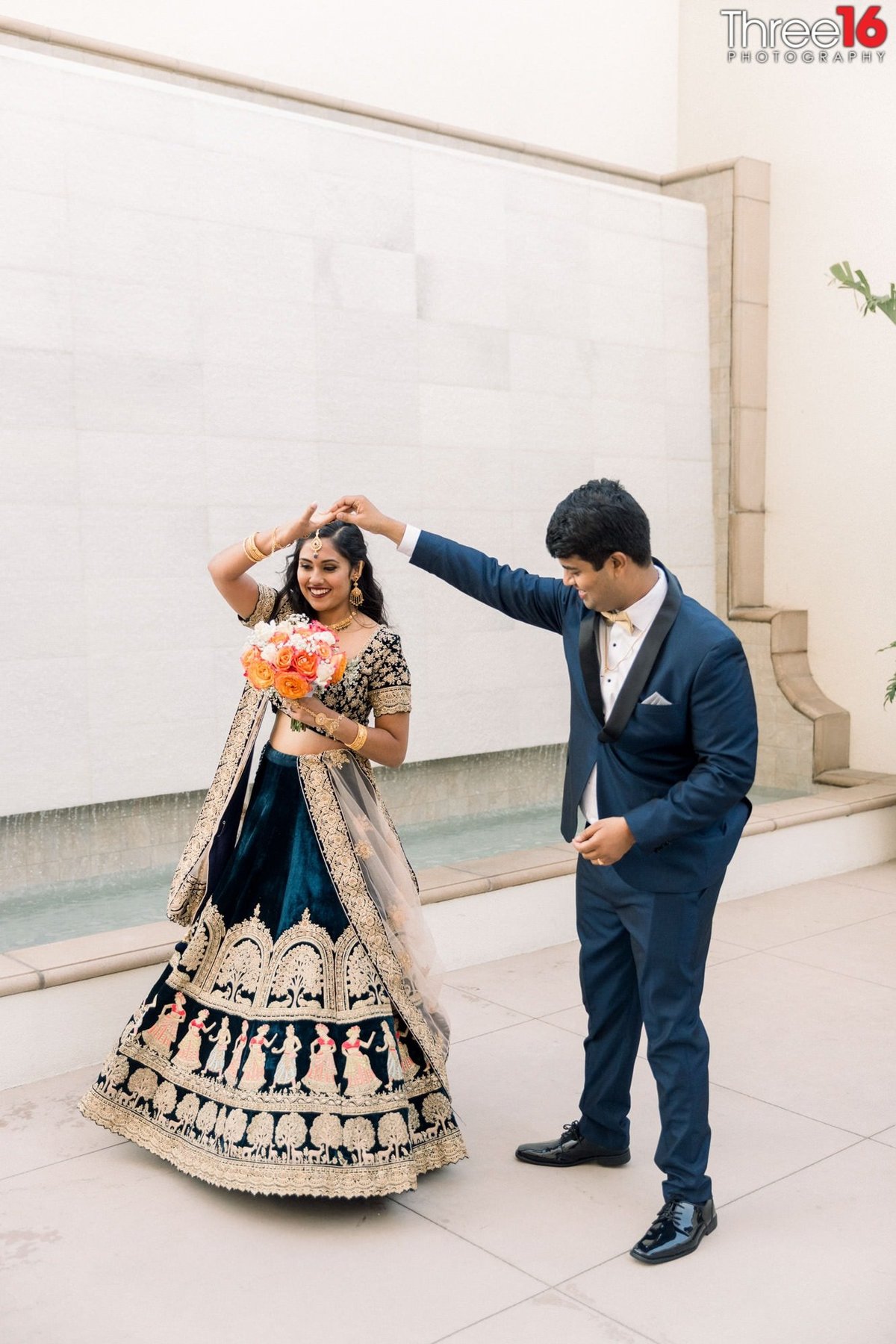 Groom spins his Bride as she wears her traditional Indian wedding dress