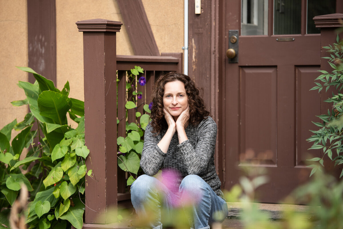A person sitting on a staircase with her chin in her hands