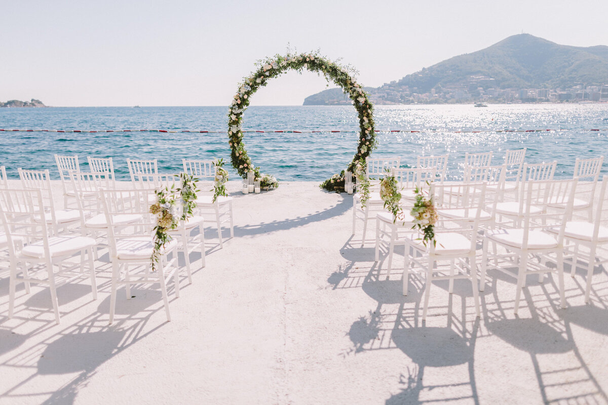 Elegant wedding ceremony site with guests chairs and colorful florals
