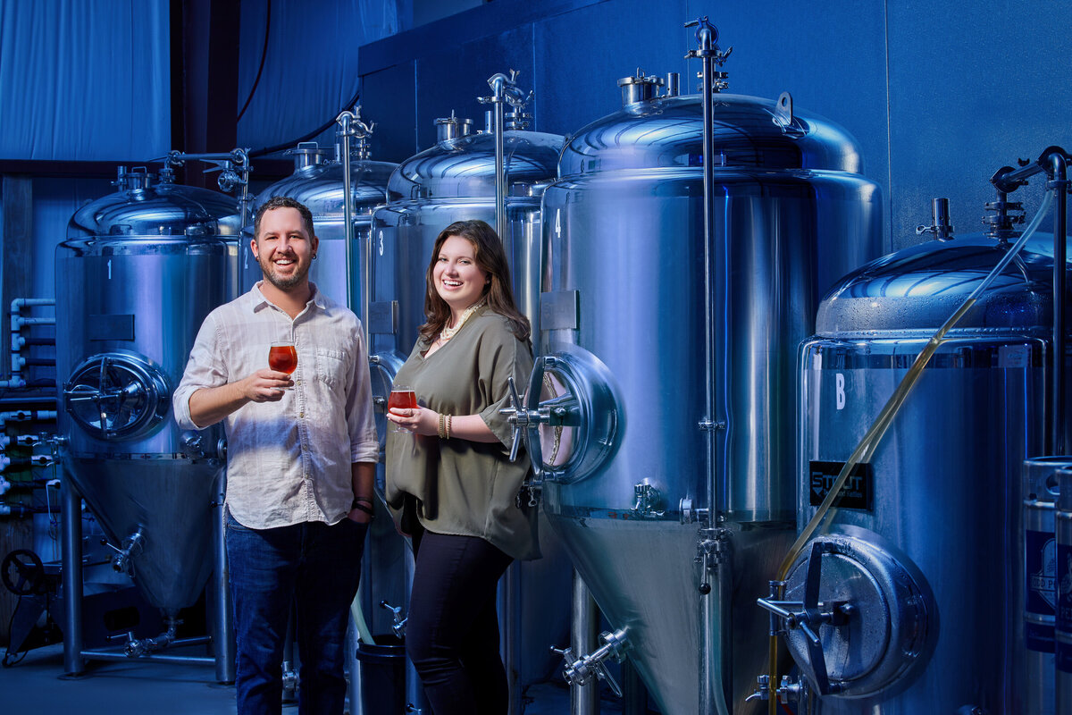 Two people standing in a brewery