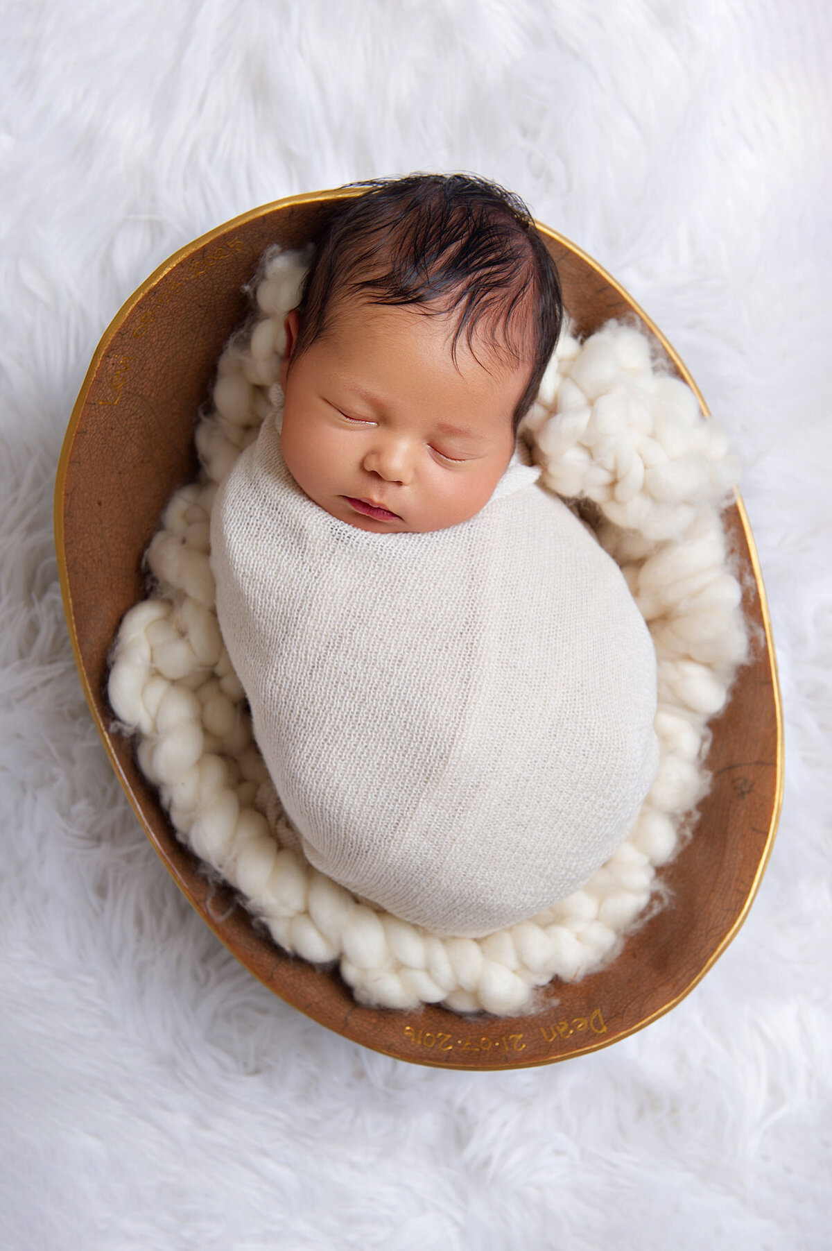 newborn sleeping in his moms belly cast wrapped in cream
