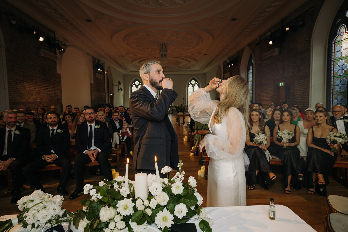 Bride and groom taking shots at the wedding alter at Smock Alley in Dublin, Ireland