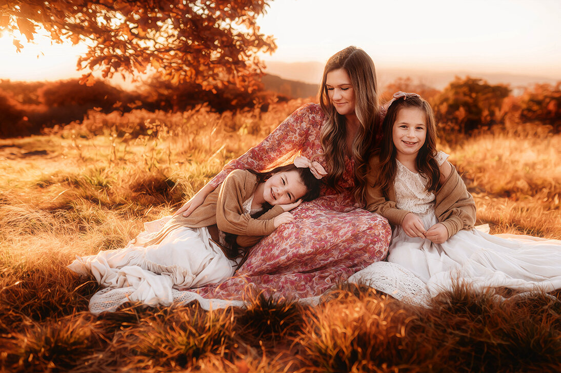 Mother embraces her daughters during photoshoot at Craggy Gardens in Asheville, NC.