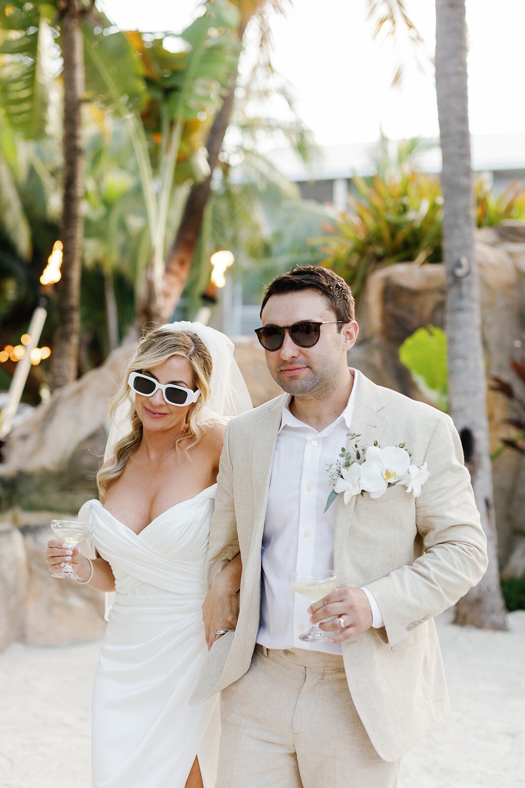 The newlyweds make a grand entrance, dressed in classic wedding attire with drinks in hand, celebrating their Florida Keys wedding.