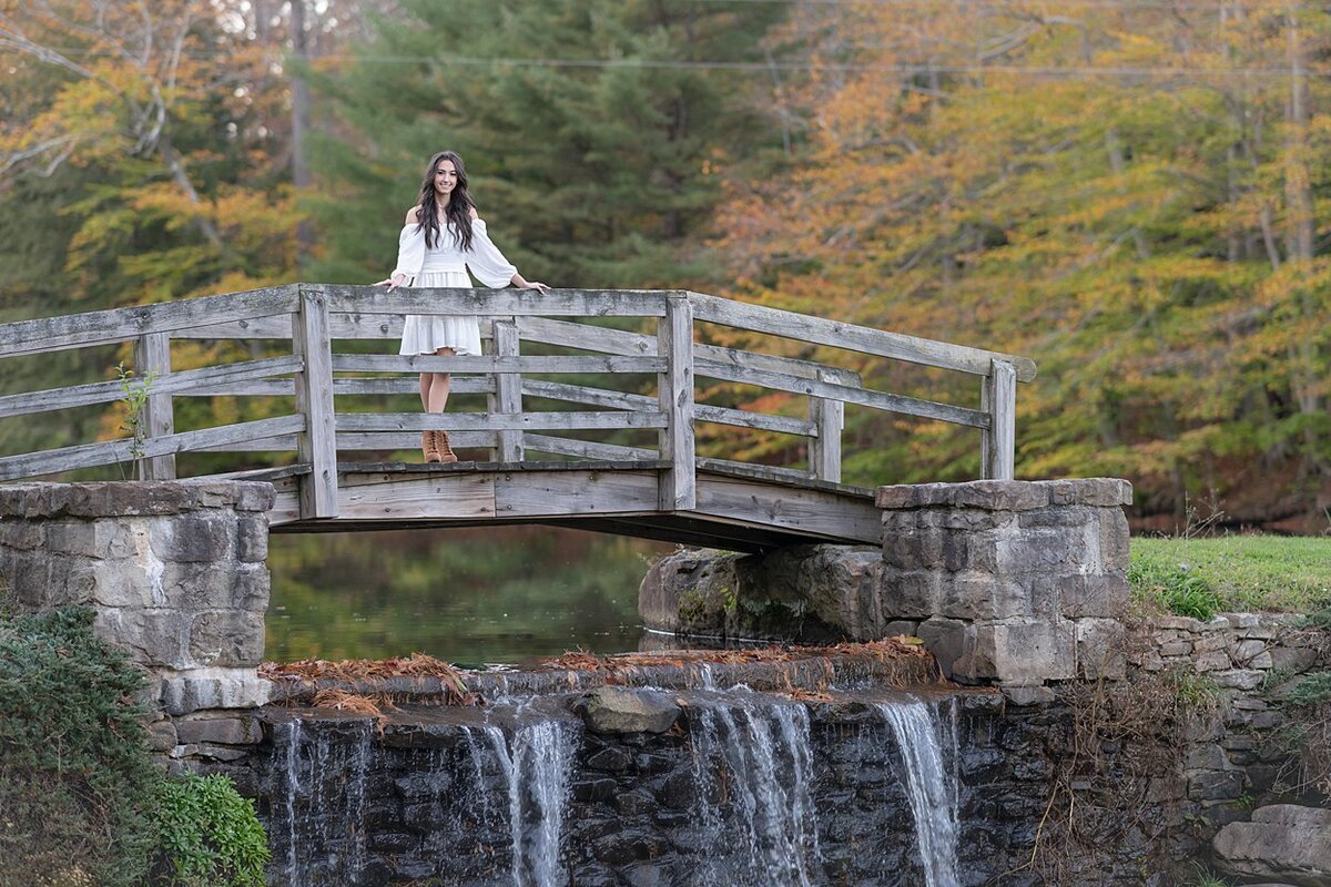 High school senior girl on bridge over waterfall