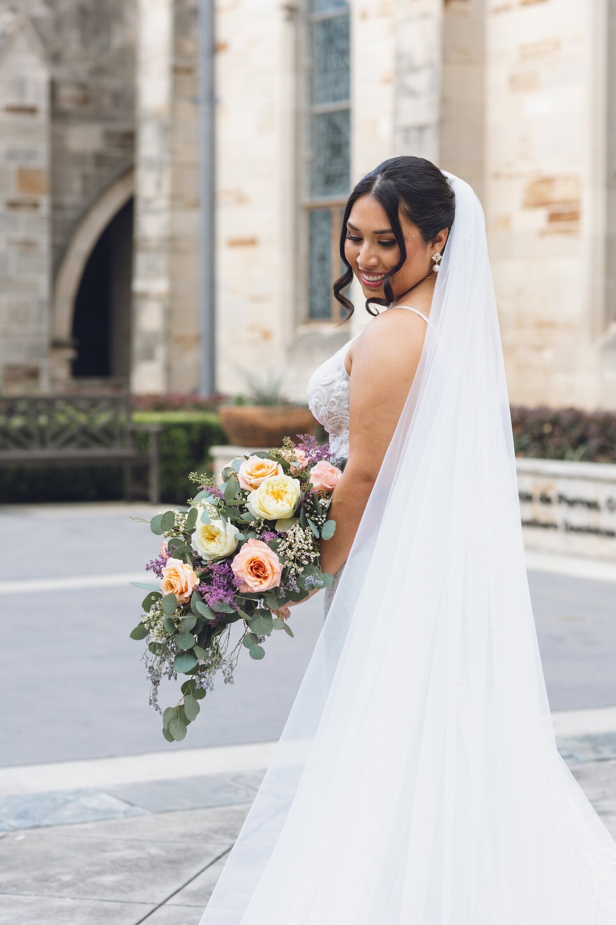 Bride holding vibrant bouquet outside Houston church