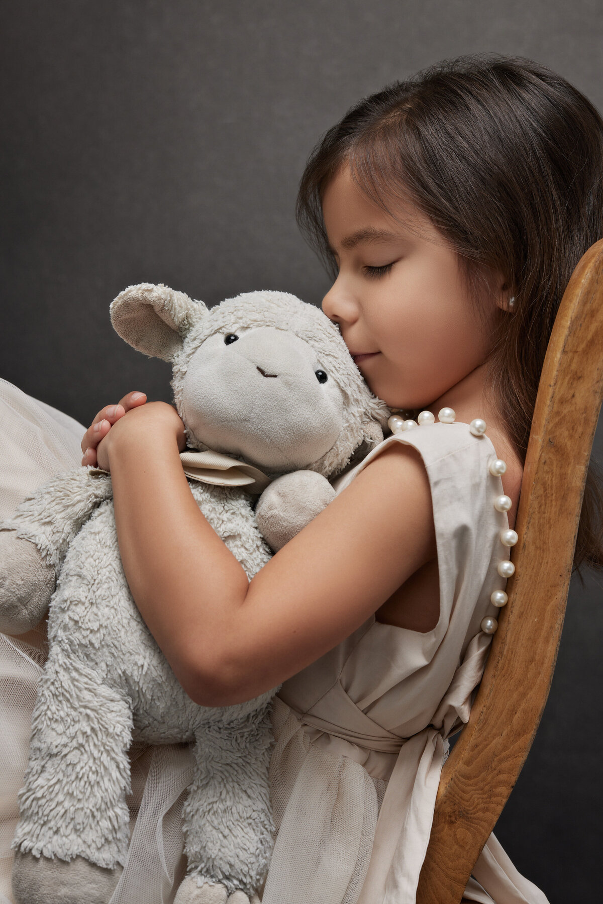 A small girl holding a stuffed animal close