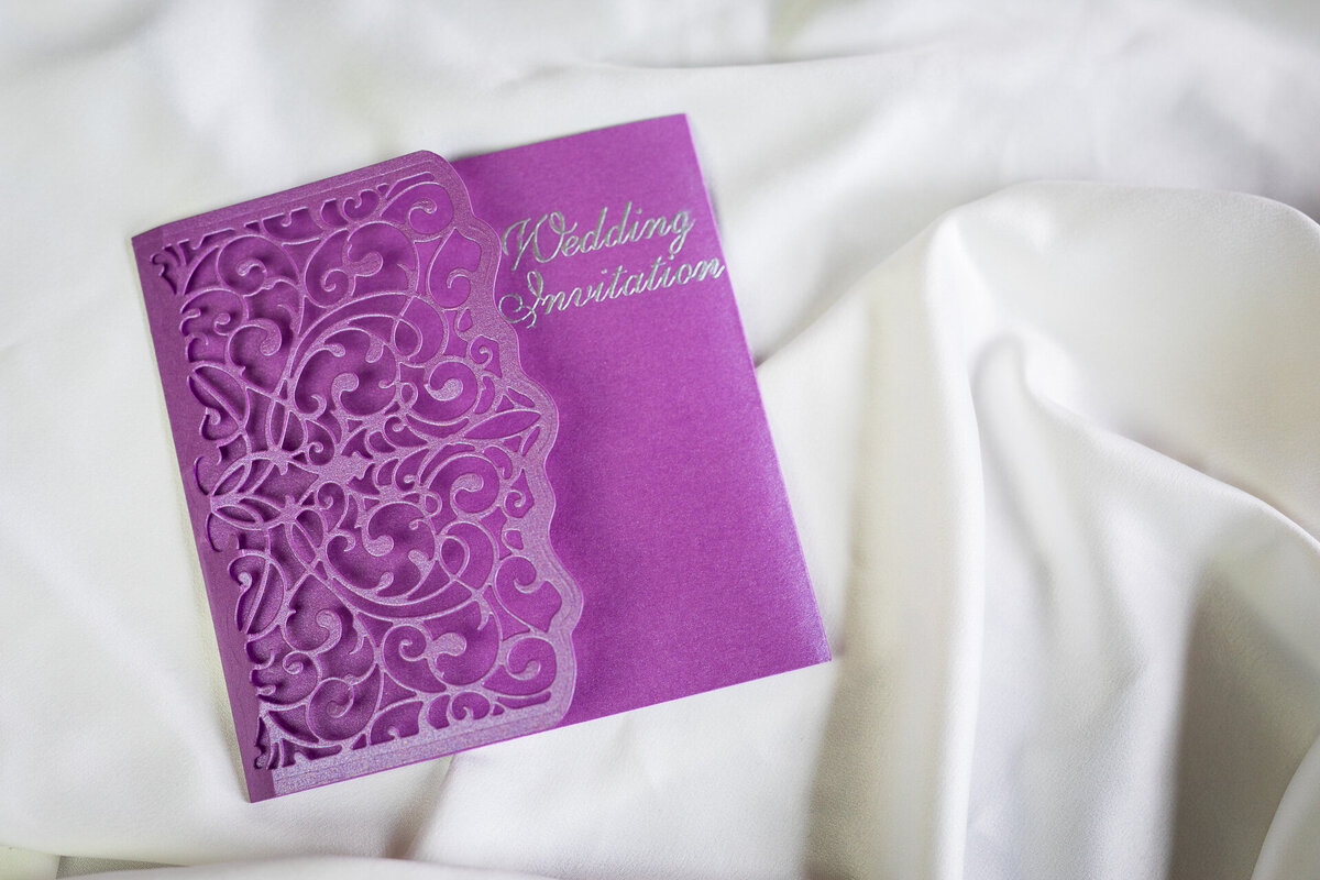 Purple wallet-style wedding invitation with handcrafted lace