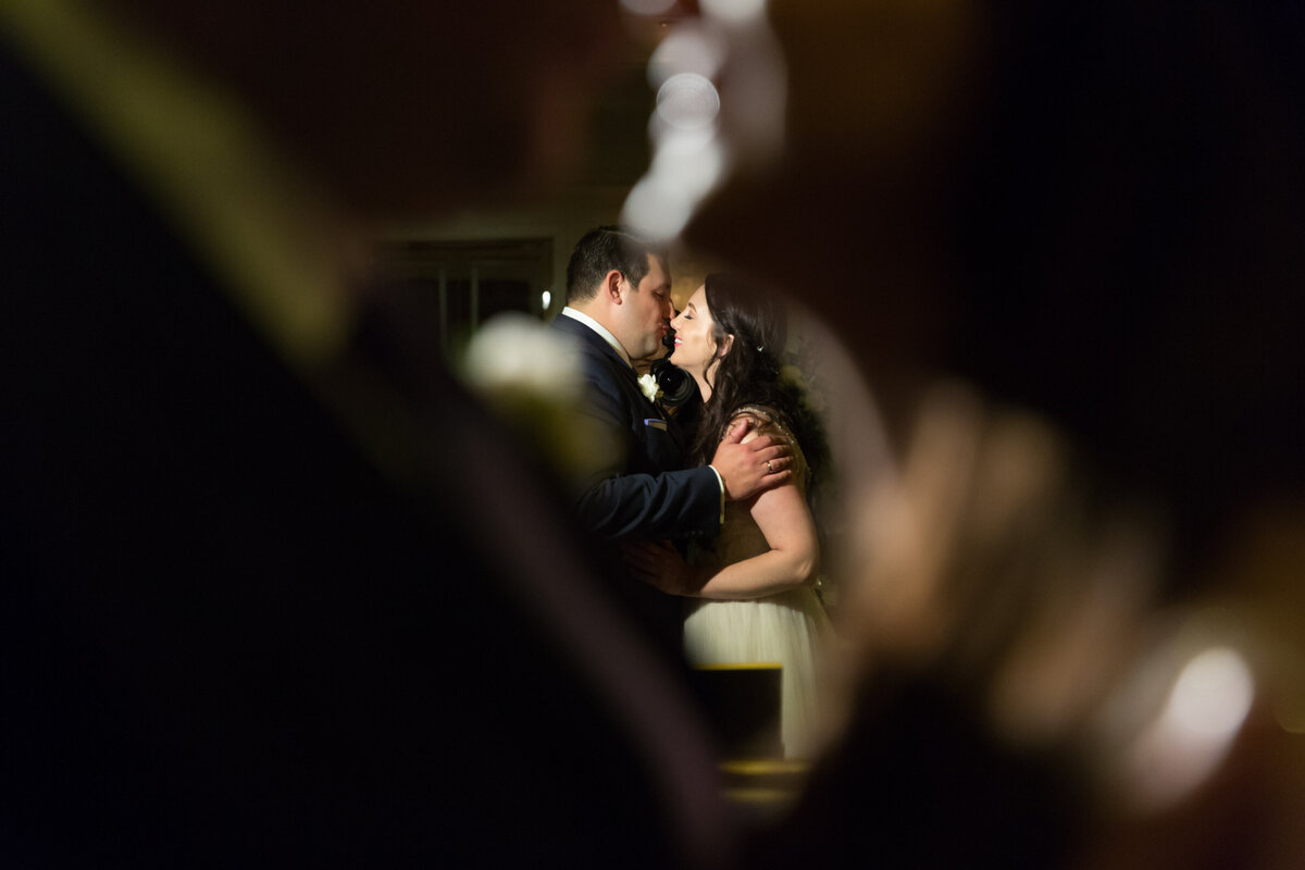 The reflection of a bride and groom kissing