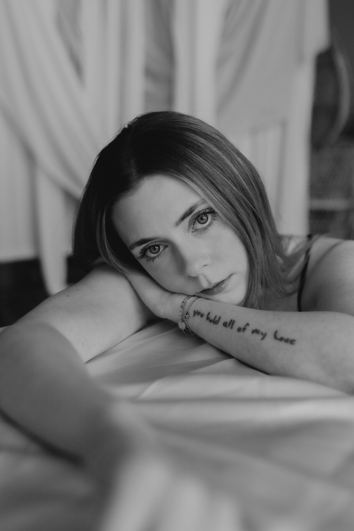Close-up of a woman resting her head on her arm, with an intimate and serene expression.