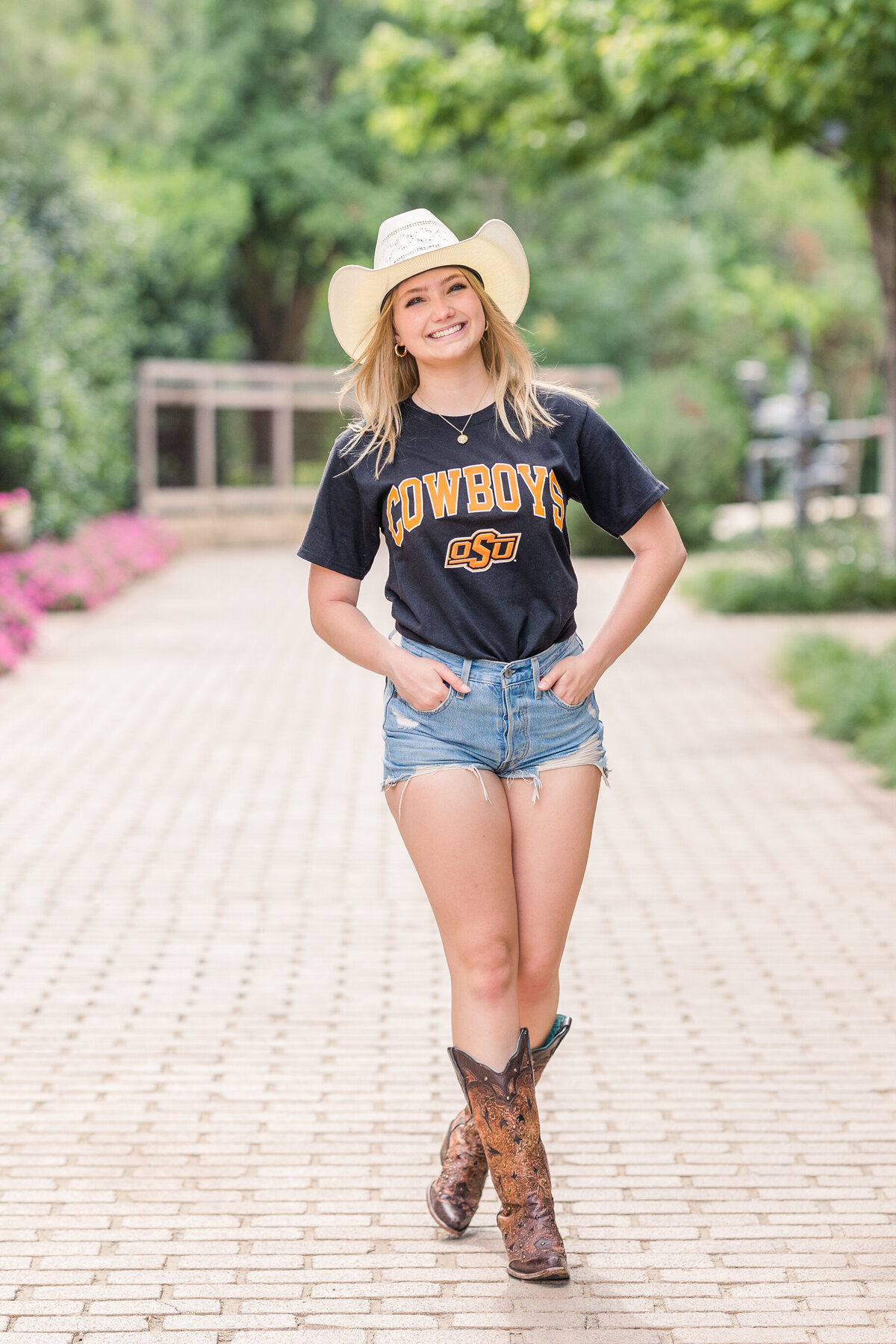 OSU-bound-senior-girl-wearing-shorts-and-cowboy-boots-photo-session-at-the-stockyards-downtown-ft-worth